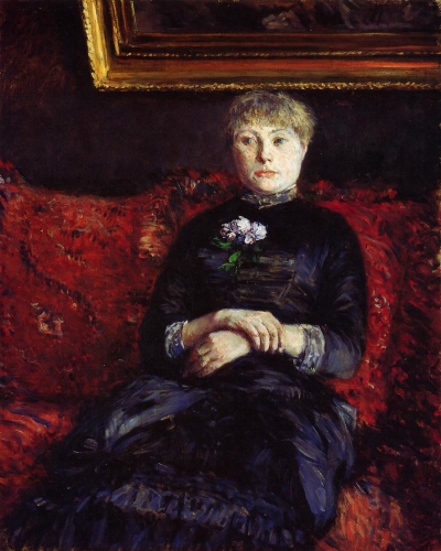 赤い花柄のソファに座る女性